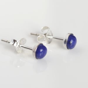 Puede incluir: Un par de pendientes de plata con piedras preciosas de lapislázuli azul.