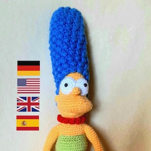 May include: A crocheted doll of a cartoon character with blue hair, a yellow face, and a green dress. The doll is standing on a white surface. © by LS 2024