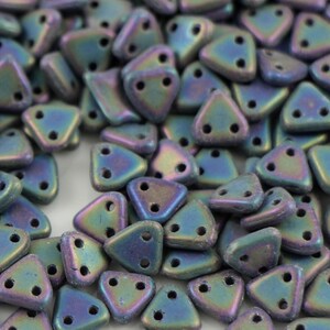 May include: A close-up of a pile of iridescent blue triangle-shaped beads. The beads have two holes in each.