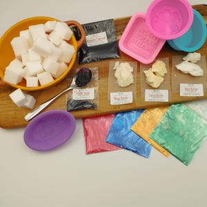 May include: A set of soap making supplies including white soap base, activated charcoal, poppy seeds, mango butter, cocoa butter, shea butter, silicone moulds, and colourful mica powder.