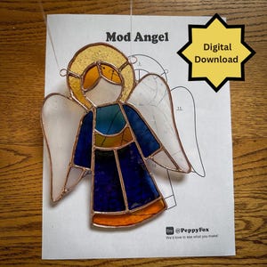 May include: A stained glass angel with a gold halo, blue and orange robes, and white wings. The angel is displayed on a printed pattern sheet with the text "Mod Angel" and "Digital Download".
