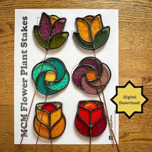 May include: Six colorful stained glass flower plant stakes. The stakes are in various shapes and colors, including purple, yellow, green, and red. The text "MCM Flower Plant Stakes" is printed on the paper. A yellow starburst graphic reads "Digital Download".
