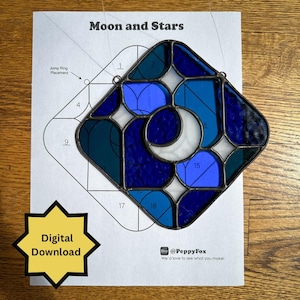 Op de afbeelding: Een gebrandschilderde glazen zonnewijzer met een maan- en sterrenontwerp in blauw- en wittinten. Het ontwerp staat op een gedrukt patroon met de tekst "Moon and Stars" en "Digital Download". De Etsy shopnaam @PeppyFox is ook zichtbaar.