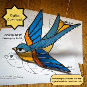 Op de afbeelding: Een gebrandschilderde zwaluw in vlucht, met blauwe, oranje en gele glazen panelen. De vogel staat op een patroonvel met de tekst "Swallow (Swooping Left)" en "Digital Download". Inclusief patronen voor links en rechts.