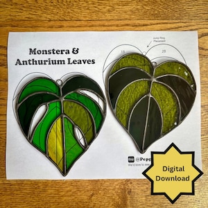 May include: Two stained glass leaf ornaments, one with a split of yellow and green, the other with shades of green. The text "Monstera & Anthurium Leaves" is above the leaves. A digital download star graphic is in the lower right.