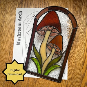Könnte beinhalten: Buntglas-Pilzbogen mit roten, orangefarbenen und cremefarbenen Pilzen, grünen Blättern und einem strukturierten Hintergrund. Der Rahmen ist dunkelbraun. Ein Papier mit dem Text "Mushroom Arch" und ein "Digital Download"-Aufkleber sind ebenfalls sichtbar.