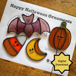 May include: A selection of stained glass Halloween ornaments. The image shows a bat, pumpkin, candy corn, and crescent moon. The ornaments are in orange, yellow, purple, and white. The text "Happy Halloween Ornaments" is at the top.