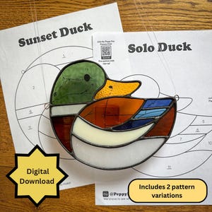 May include: A stained glass duck in shades of green, orange, and blue, displayed with pattern sheets titled "Sunset Duck" and "Solo Duck." The image includes text that says "Digital Download" and "Includes 2 pattern variations."