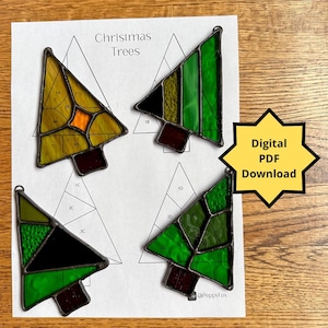 May include: Four stained glass Christmas tree patterns on a white sheet of paper. The trees are made of green, yellow, orange, black, and brown glass. The paper has the words "Christmas Trees" printed at the top. The words "Digital PDF Download" are printed on a yellow star shape.