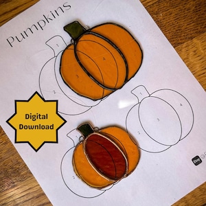 May include: A digital download pattern for stained glass pumpkins. The pattern includes two pumpkins, one with a red centre and one with an orange centre. The pattern is numbered 1-4 for easy assembly.