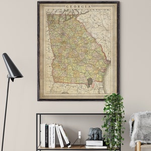 May include: Vintage map of Georgia in a black frame, with a light brown background and yellow, green, and red markings. The map is titled "GEORGIA" in a black font.