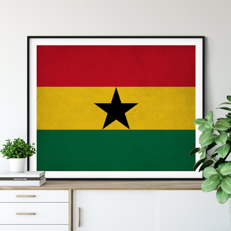 May include: A framed print of the flag of Ghana. The flag is red, yellow, and green with a black star in the center.