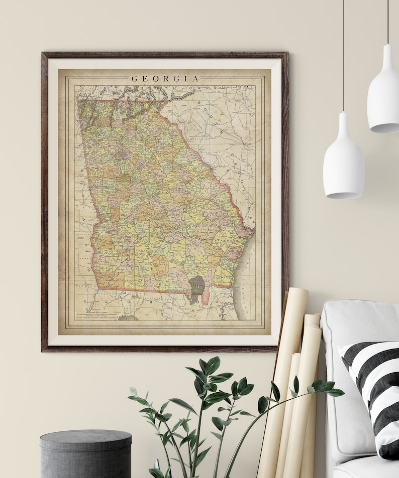 May include: Vintage map of Georgia with county borders and railroads. The map is printed on aged paper with a brown border and the word "GEORGIA" printed at the top.