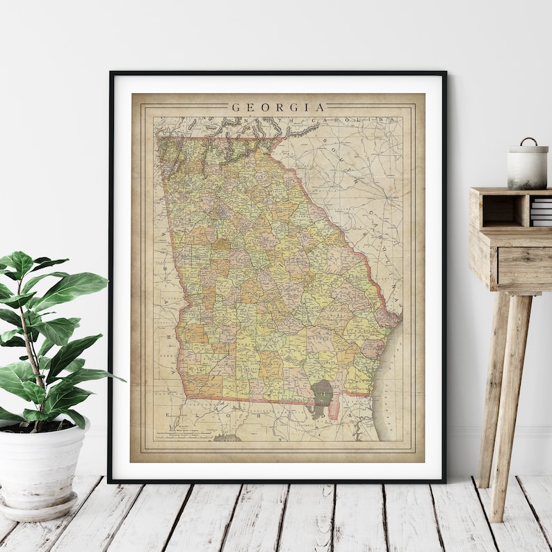 May include: Vintage map of Georgia with a detailed outline of the state and its counties. The map is printed on aged paper with a cream background and features a faded brown and yellow color scheme. The title "GEORGIA" is printed in black at the top of the map.