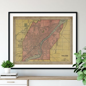 May include: An antique map of Toledo, Ohio, printed in brown, yellow, and red ink. The map shows the city's streets, rivers, and parks. The title "TOLEDO" is printed in the bottom right corner.