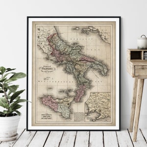 May include: An antique map of the Kingdom of Naples, the Two Sicilies, with a scale and key. The map is printed on aged paper with a cream background and features a detailed outline of the Italian peninsula and the island of Sicily. The map is framed in black.