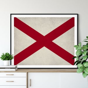 Peut inclure: Une impression encadrée du drapeau de l'État de l'Alabama. Le drapeau est un champ blanc avec une croix rouge qui s'étend jusqu'aux bords du drapeau.