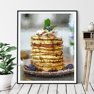 May include: A stack of golden brown pancakes topped with a dollop of whipped cream and a single blueberry. The pancakes are drizzled with syrup and garnished with a sprig of green mint.