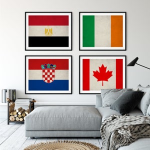 May include: Four framed prints of national flags. The flags are of Egypt, Ireland, Croatia, and Canada. The flags are displayed on a white wall in a living room setting.