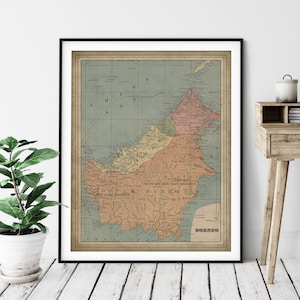May include: A vintage map of Borneo, showing the different territories of British North Borneo, Dutch East Borneo, and the South and East Coast Residency of British Borneo. The map is printed on aged paper with a light blue background and features brown and red lines and text.