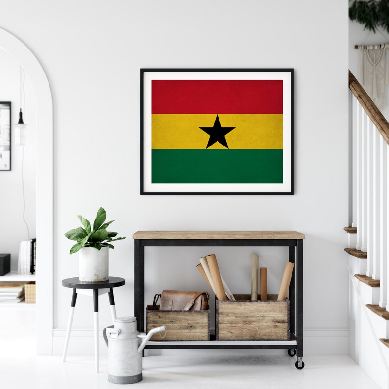 May include: A framed print of the flag of Ghana. The flag is red, yellow, and green with a black star in the center.