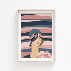 May include: Art print in a wooden frame. The artwork depicts a woman in a blue cloche hat with a pink ribbon, set against a backdrop of pink and blue horizontal stripes. The woman wears a pearl necklace and holds a bouquet. The style is geometric and stylized.