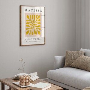 以下が含まれることがあります： 黄色の抽象的なデザインと「MATISSE MUS&Eacute;E D'ORSAY Rue de la L&eacute;gion d'honneur」というテキストが書かれた額縁に入ったポスター。