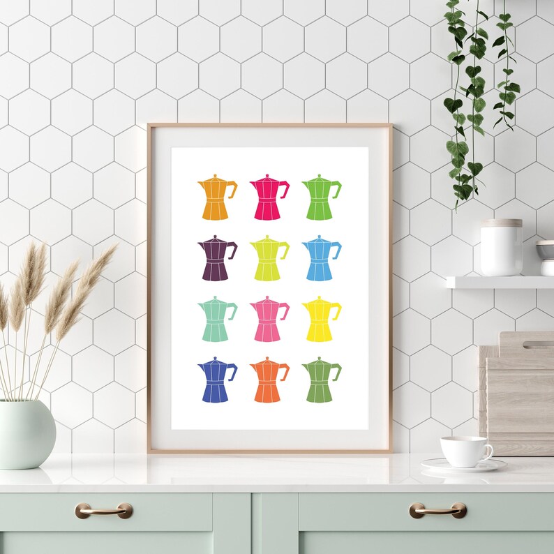May include: A white framed print with a colorful design of 12 Italian coffee pots. The coffee pots are arranged in four rows of three, with each row featuring a different color. The colors are red, orange, yellow, green, blue, purple, pink, teal, light blue, dark blue, and brown.