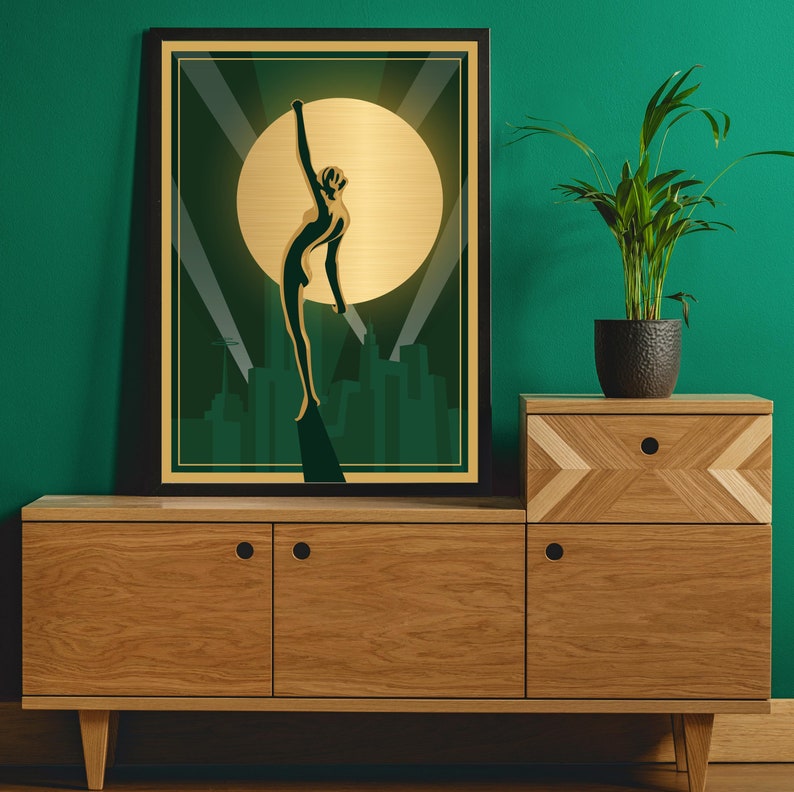 Peut inclure: Une estampe encadr&eacute;e avec une silhouette dor&eacute;e d'une femme levant les bras contre un fond vert et or. La femme se tient devant un horizon urbain.