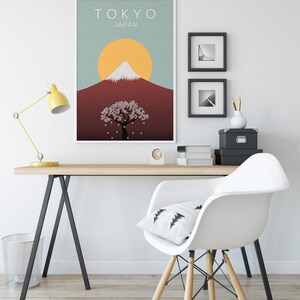 Puede incluir: Un p&oacute;ster minimalista con un marco blanco que presenta una ilustraci&oacute;n estilizada del Monte Fuji, un &aacute;rbol de cerezo en flor y un sol amarillo. El p&oacute;ster tiene el texto "TOKYO JAPON" en la parte superior.