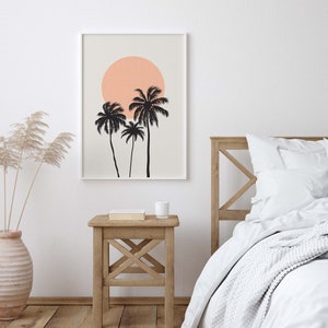 May include: A framed print with a minimalist design featuring three palm trees silhouetted against a peach-colored sun on a light beige background.