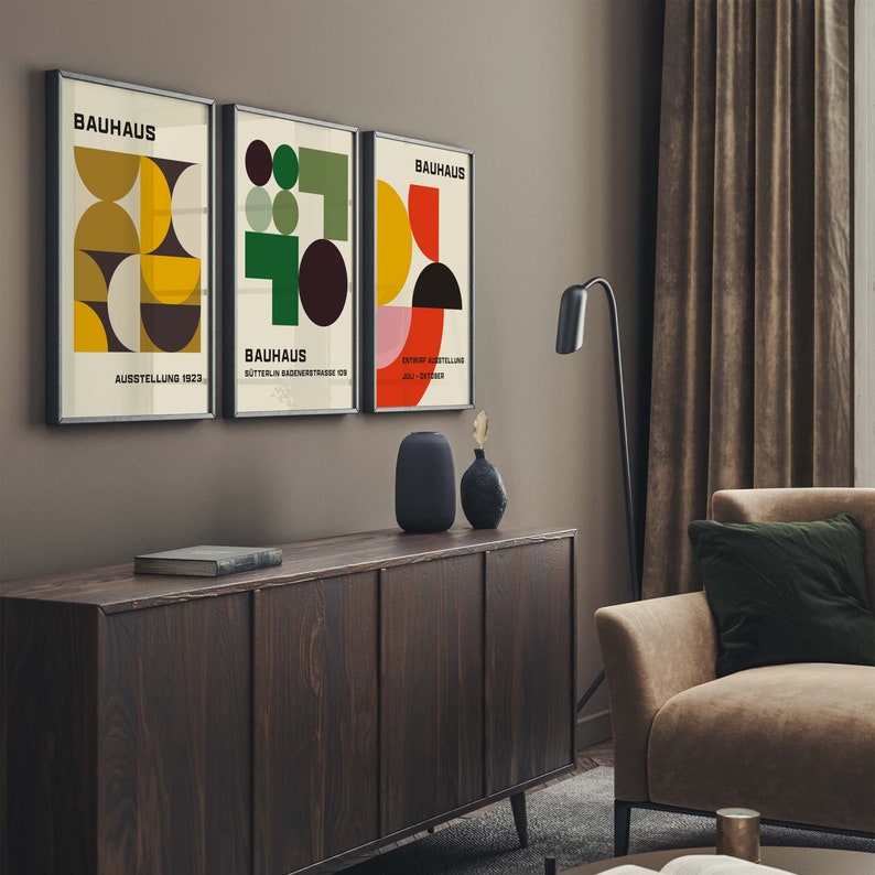 May include: Three framed prints with geometric designs in red, yellow, green, and black. The prints are titled "Bauhaus" and feature the text "Ausstellung 1923" and "Sommer Ausstellung Juli - Oktober".