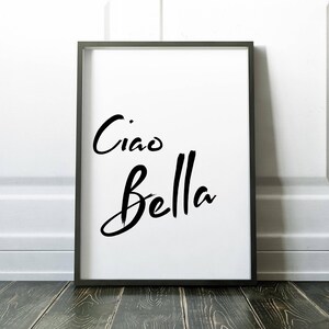 May include: A black framed print with the text "Ciao Bella" in a white background.