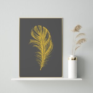 May include: A gold feather illustration on a dark gray background. The image is framed and ready to hang.