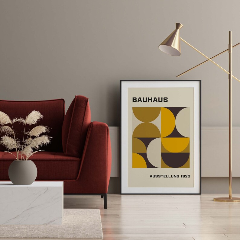 May include: A framed poster with a geometric design in shades of yellow, brown, and white. The poster has the text "BAUHAUS" and "AUSSTELLUNG 1923" printed on it.