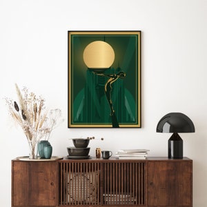 Peut inclure: Une impression d'art encadr&eacute;e avec un fond vert et une silhouette dor&eacute;e d'une femme plongeant dans une piscine. L'impression pr&eacute;sente un grand cercle dor&eacute; dans le coin sup&eacute;rieur gauche, ressemblant &agrave; une pleine lune.