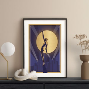 May include: A framed art print featuring a gold silhouette of a woman reaching up towards a large gold moon against a dark blue background with a cityscape in the foreground.