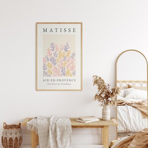 May include: A framed print of a Matisse painting featuring a colorful abstract design of leaves in shades of pink, purple, and yellow. The print is titled "Matisse" and includes the text "Aix-en-Provence, Pavillon de Vend&ocirc;me".