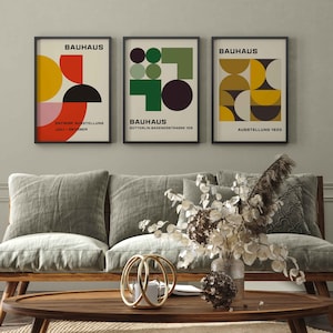 May include: Three framed Bauhaus posters with geometric designs in red, yellow, green, and black. The posters have the text "Bauhaus" and "Ausstellung 1923".