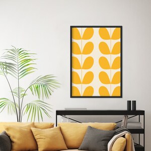 May include: A framed print with a geometric pattern of yellow leaf shapes on a cream background.