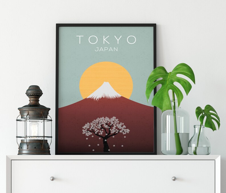 Puede incluir: Un p&oacute;ster minimalista con un dise&ntilde;o gr&aacute;fico del Monte Fuji, un &aacute;rbol de cerezo en flor y un sol amarillo. El p&oacute;ster tiene el texto "TOKYO JAP&Oacute;N" en la parte superior.