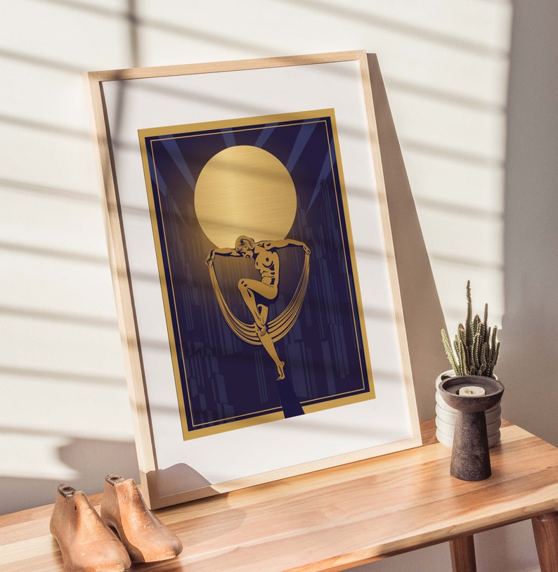 May include: A gold framed print with a gold silhouette of a dancer against a dark blue background with a large gold moon in the upper center of the image.