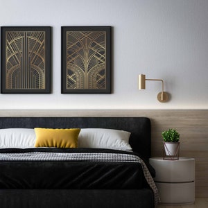 May include: A black bed frame with a white headboard and a black and white patterned blanket. There are two gold framed prints with geometric designs above the bed. A small plant in a white pot sits on a white nightstand.