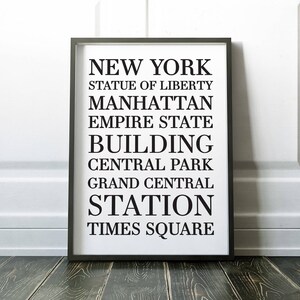May include: Black and white typography print with the text "NEW YORK" and a list of iconic New York City landmarks, including the Statue of Liberty, Manhattan, Empire State Building, Central Park, Grand Central Station, and Times Square.