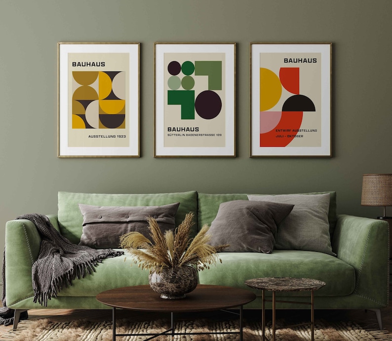 May include: Three framed prints with geometric designs in shades of yellow, green, red, and black. The prints are titled "Bauhaus" and feature the text "Ausstellung 1923", "Sommerlin Badensstrasse 109", and "Entwurf Ausstellung Juli - Oktober".