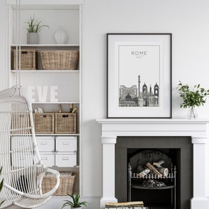 May include: A black and white cityscape print with the text "ROME ITALY" above the skyline. The print is framed in a black frame and hangs above a white fireplace with a black hearth. The fireplace has a wood-burning fire inside.