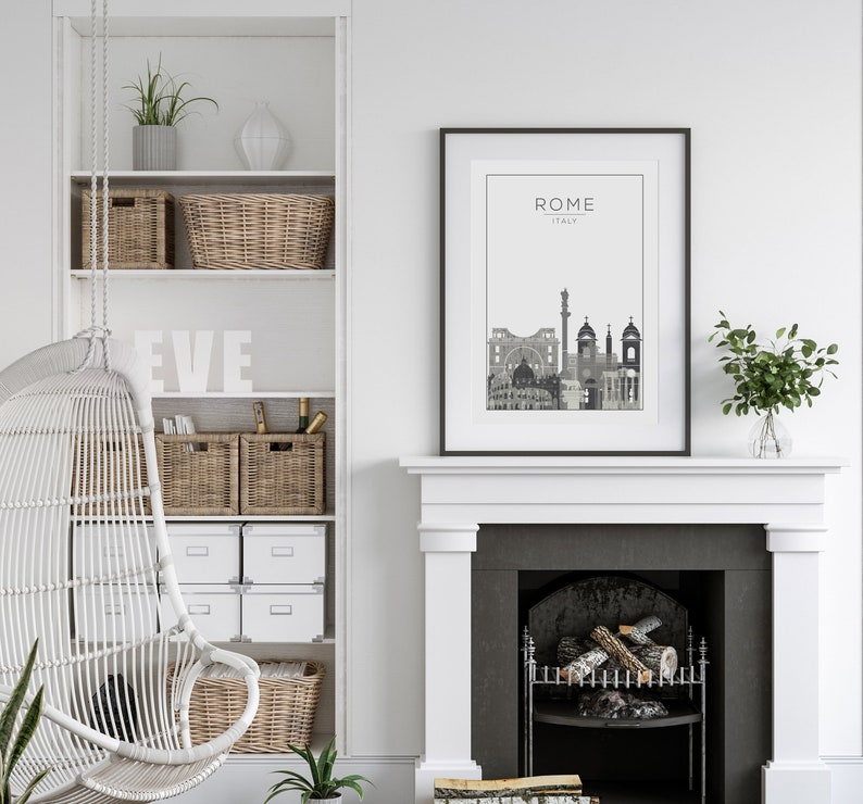 May include: A black and white cityscape print with the text "ROME ITALY" above the skyline. The print is framed in a black frame and hangs above a white fireplace with a black hearth. The fireplace has a wood-burning fire inside.
