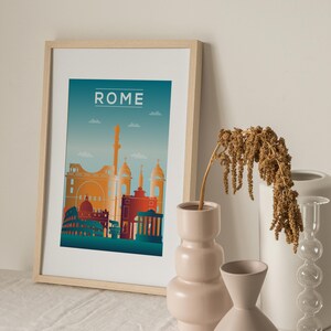 May include: A framed print with a cityscape of Rome, Italy. The print is on a white background with a blue gradient sky. The buildings are in shades of orange, red, and yellow. The word "ROME" is printed in white at the top of the print.