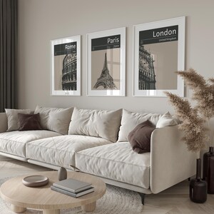 Peut inclure: Trois impressions en noir et blanc encadr&eacute;es de monuments c&eacute;l&egrave;bres. Les impressions sont accroch&eacute;es &agrave; un mur beige clair au-dessus d'un canap&eacute; blanc. Les impressions repr&eacute;sentent le Colis&eacute;e &agrave; Rome, la tour Eiffel &agrave; Paris et Big Ben &agrave; Londres.