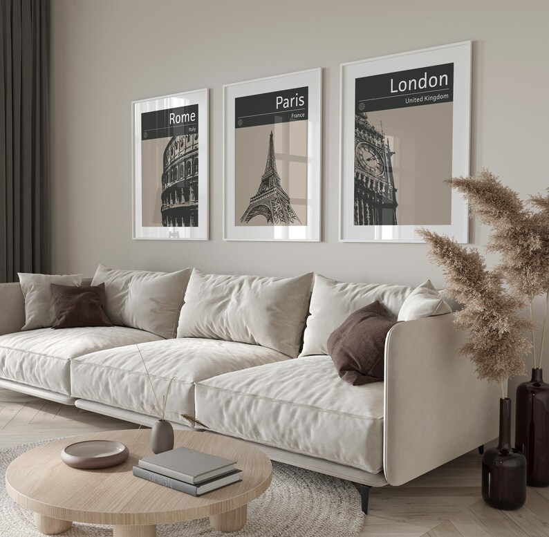 Peut inclure: Trois impressions en noir et blanc encadr&eacute;es de monuments c&eacute;l&egrave;bres. Les impressions sont accroch&eacute;es &agrave; un mur beige clair au-dessus d'un canap&eacute; blanc. Les impressions repr&eacute;sentent le Colis&eacute;e &agrave; Rome, la tour Eiffel &agrave; Paris et Big Ben &agrave; Londres.